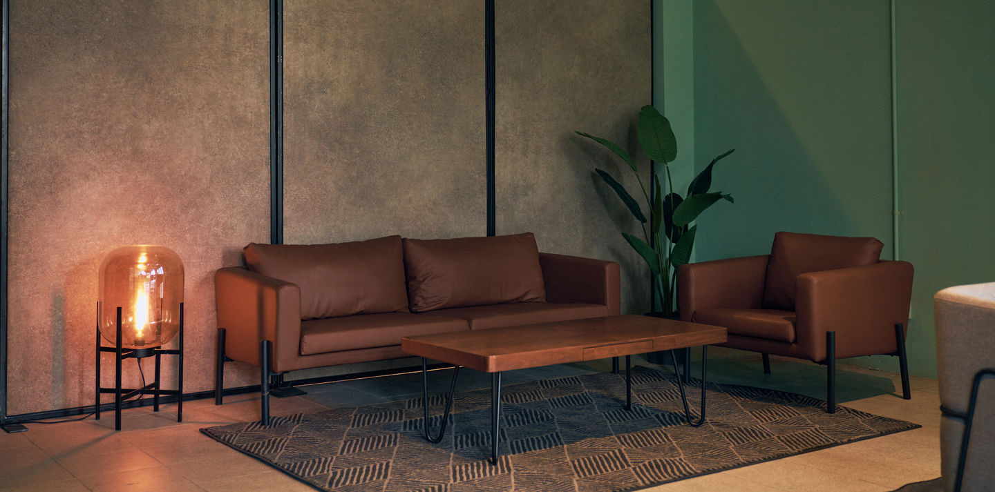 Open lounge — leather seating, warm lighting, textured walls